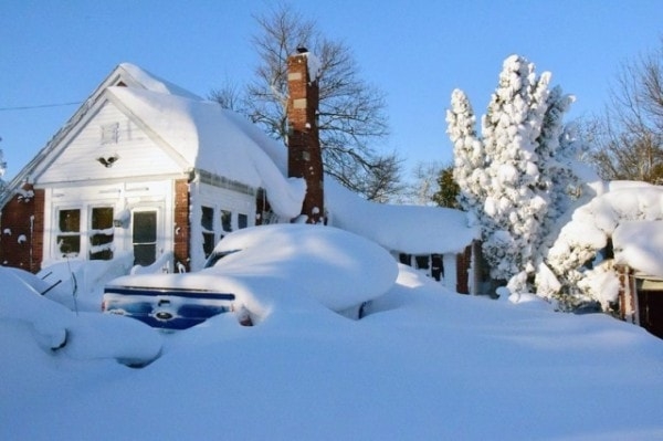 A house and vehicle covered in snow. Image by Novinite.